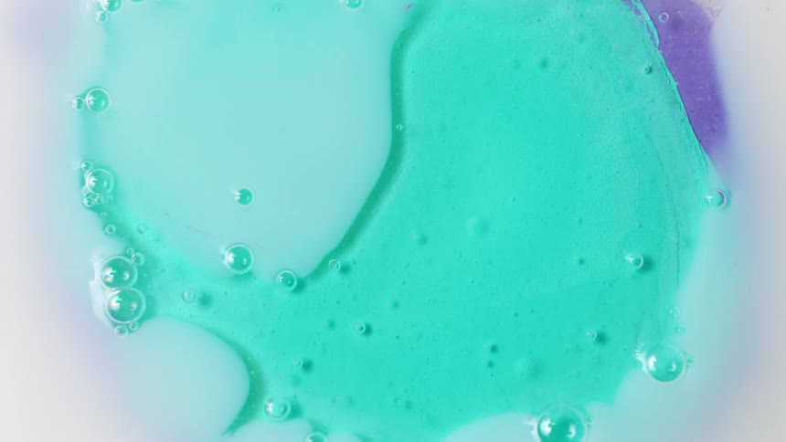Abstract footage of bubbles in green liquid as it moves
