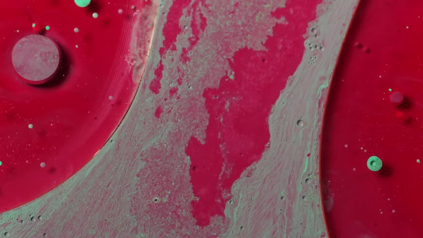 Red mixed paint moving slowly through on a painting