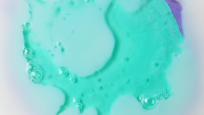 Light reflects on bubbles sitting on a green surface