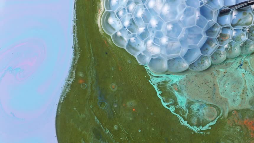 Light blue bubbles are rapidly moving over a green area pushing the green into the pastel blue and pink area