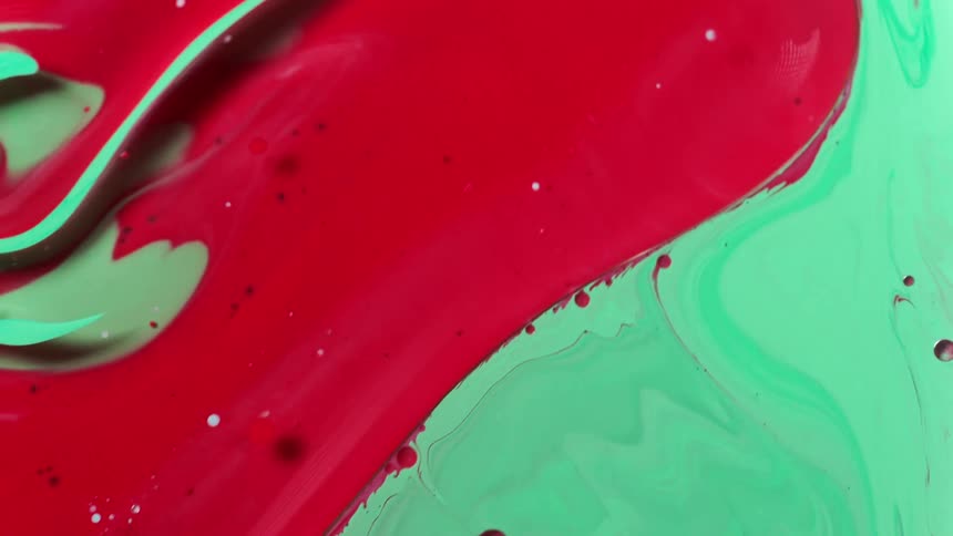 A close up of green and red paint being mixed together