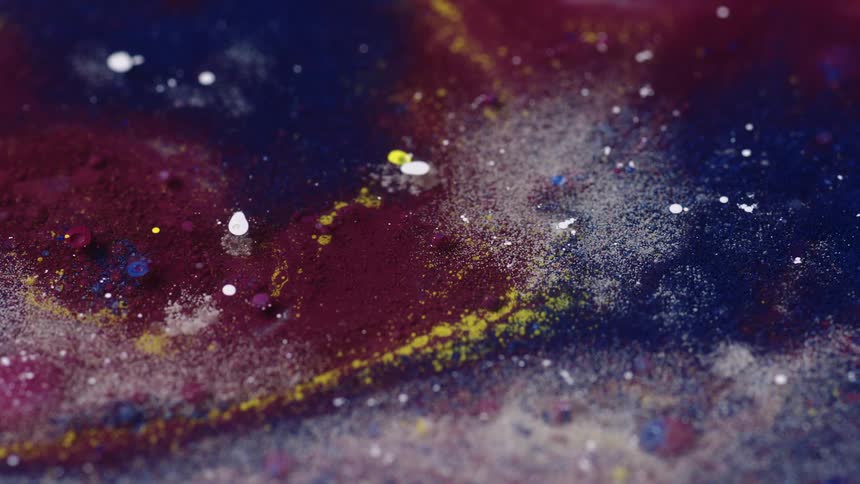 A close up of a painting of a galaxy is shown with purples and blues and white glitter