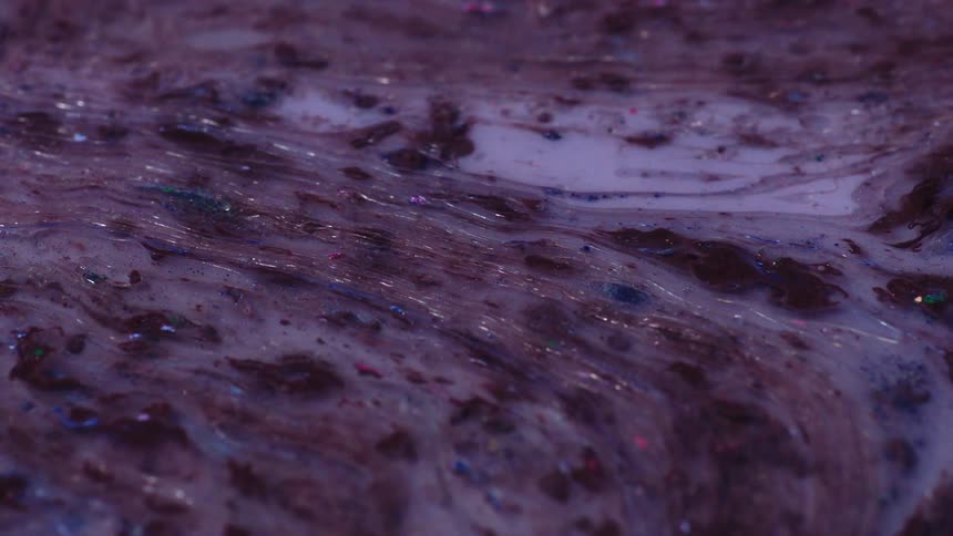 A liquid substance that looks murky with white and brown colors is flowing to the left