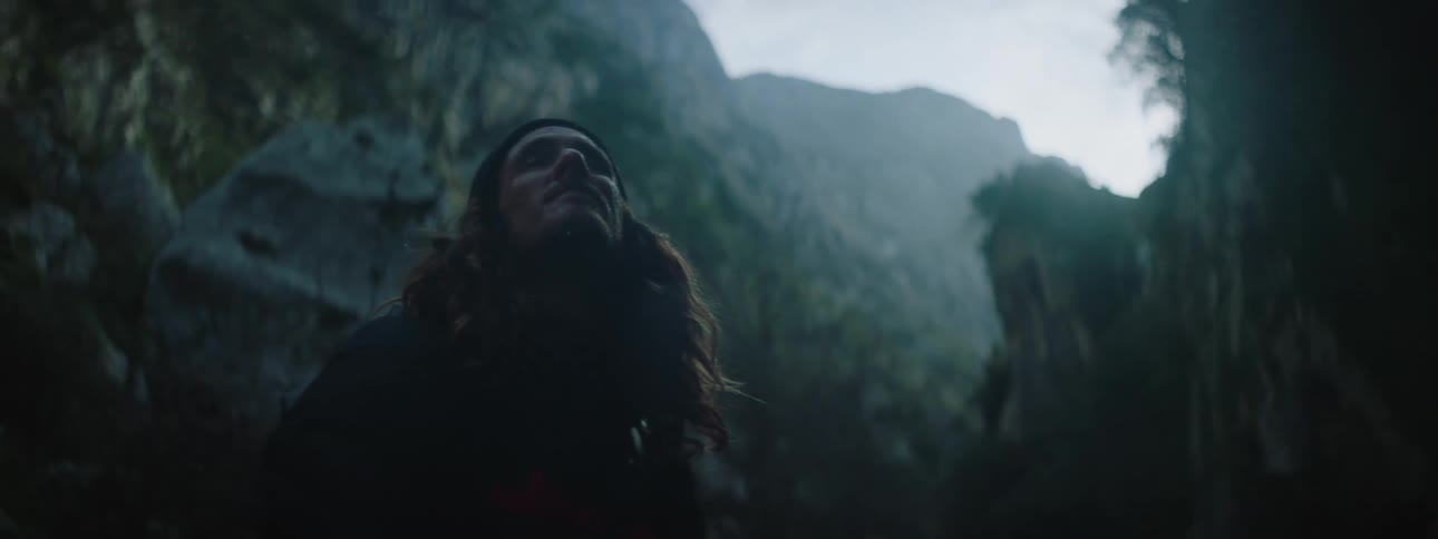 A man looks up at a mountain