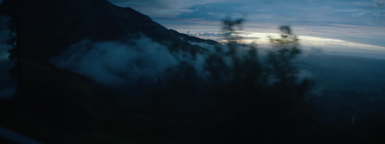Fog is covering the mountain landscape during dusk