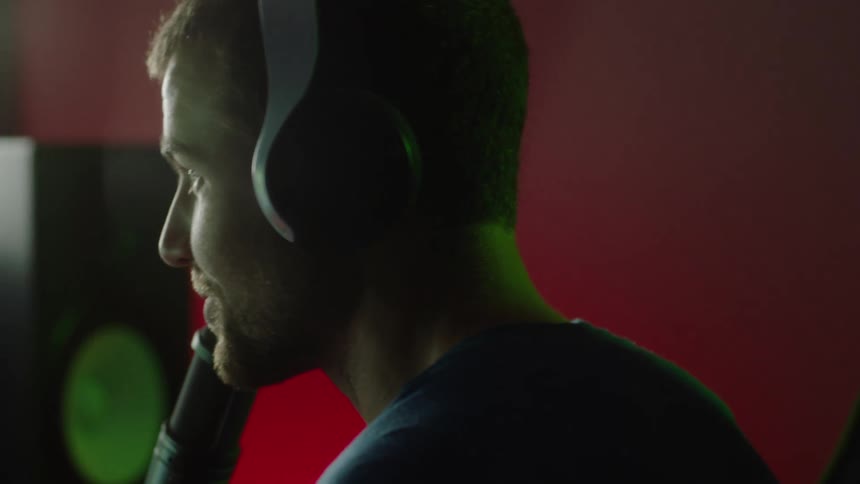A male is talking into his microphone while sitting at a computer