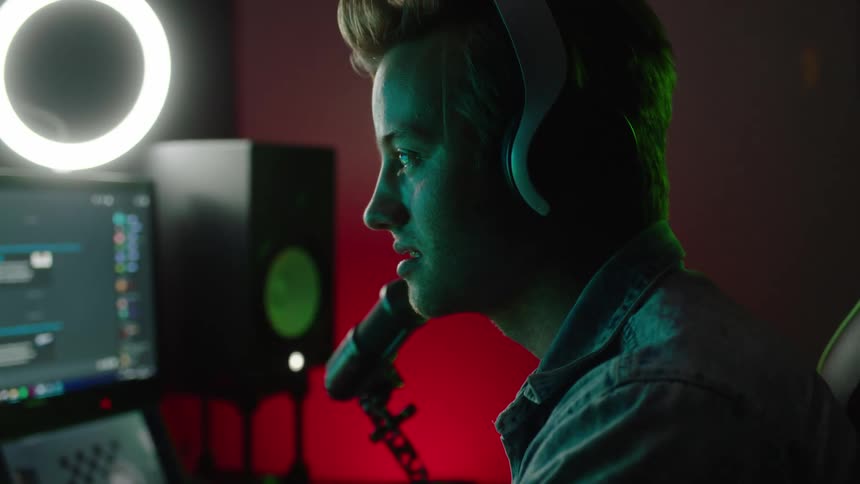 A male is playing video games and talking on his mic
