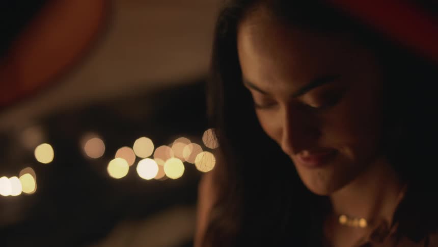 Light shines on a womans face as she looks up and smiles