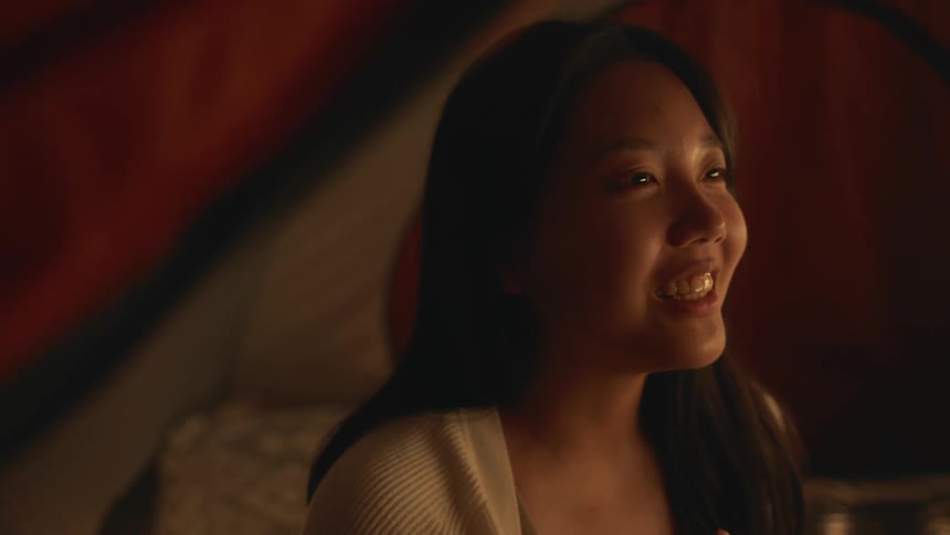 A woman is talking to someone while inside of a tent