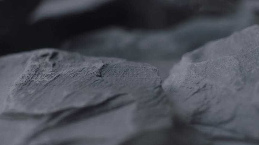 Abstract closeup of flat rock surface with light steam or smoke moving across it