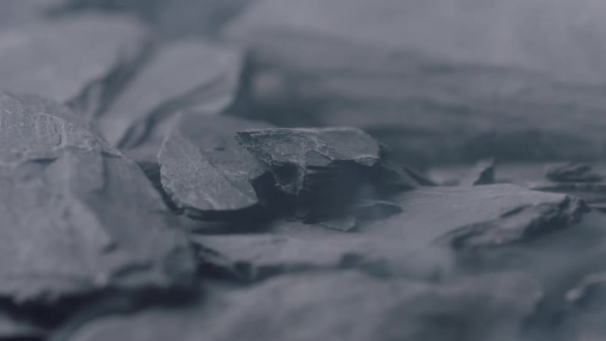 Rocks being dropped and broken on one another creating dust clouds
