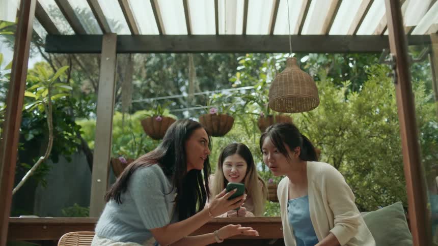 Three friends are sitting on a balcony together