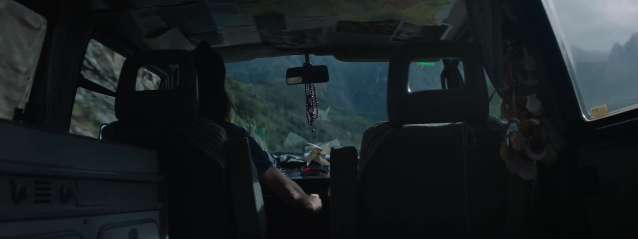 A person is driving a car through a rocky landscape