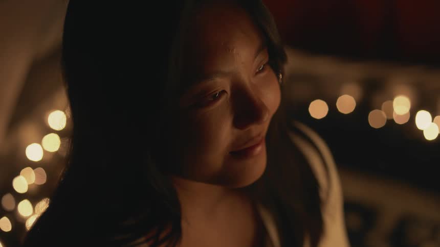 A woman is smiling and sitting inside of a tent