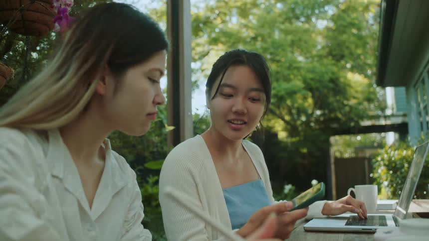 Two friends are outdoors and are hanging out in the day time