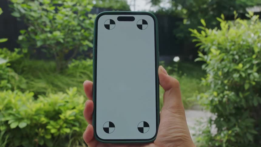 Someone is holding there phone outdoors in the middle of the day