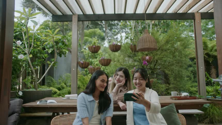 Friends are outdoors and are taking pictures with there phone