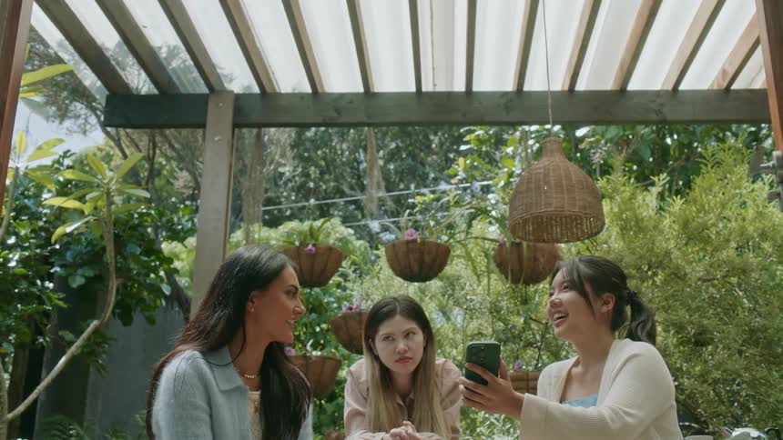Three friends are sitting outdoors together during spring