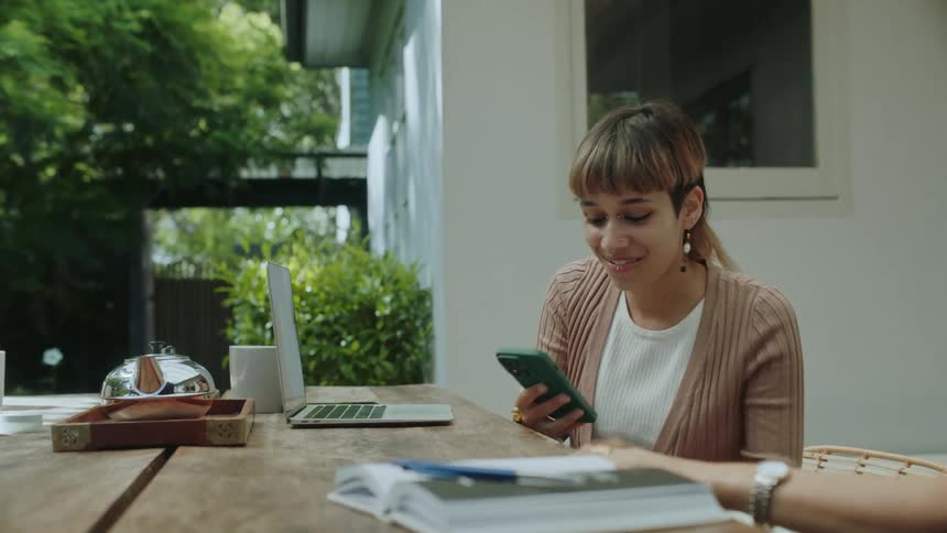 Happy young woman shows her friends a funny message she received on the phone