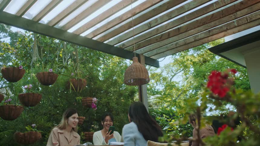 Female friends sitting on an outdoor patio on a summer day