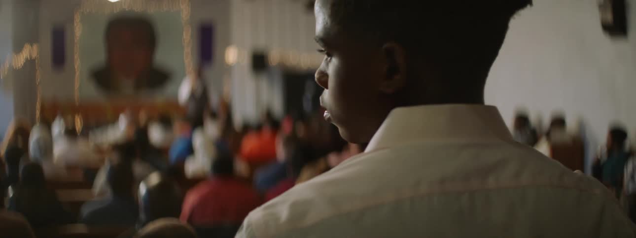 A man is standing before a church full of people