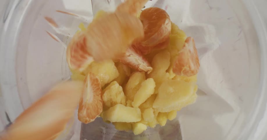 Fruits are being put into a blender