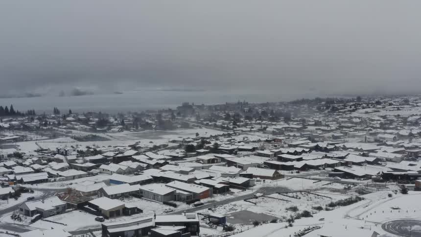 An aerial view of a snow covered city with dense fog settling over it