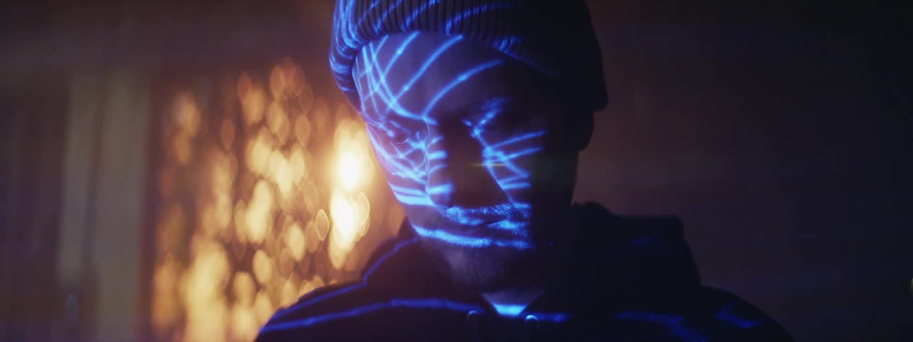 A man looking down at something casting blue lights