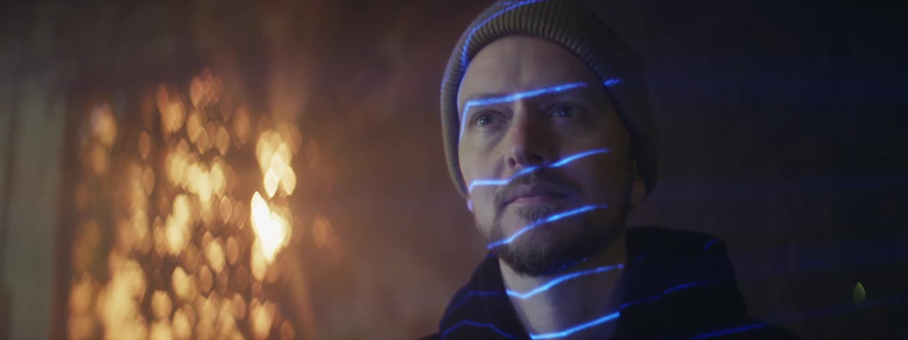 A man with blue lines shining on him