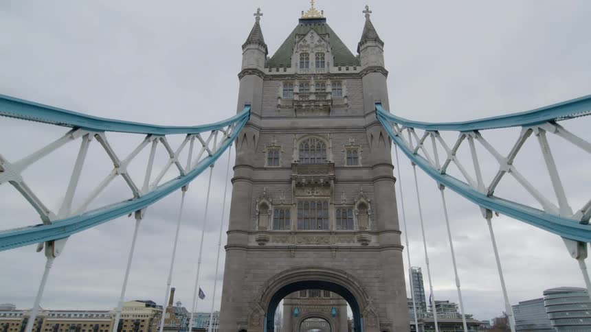 A tall tower archway connect to a bridge