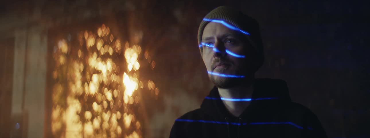 Blue lasers flash across a mans face