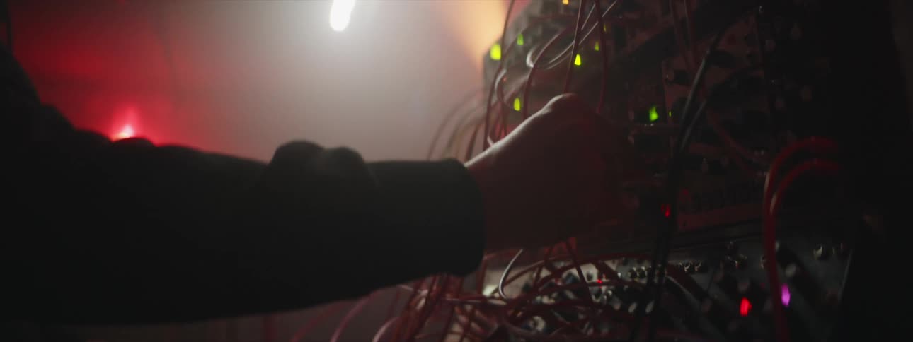 A person switching buttons and moving cords on an electronic unit