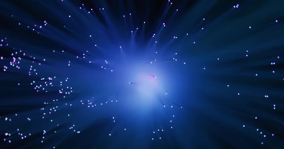 A bright light glows in the distance and rays spread across the darkness rotating with many small colored orbs