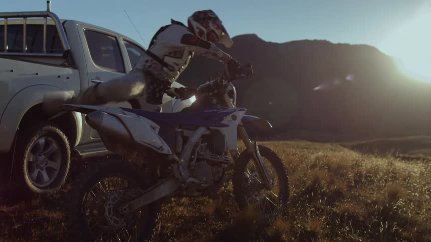 A man gets on his dirt bike