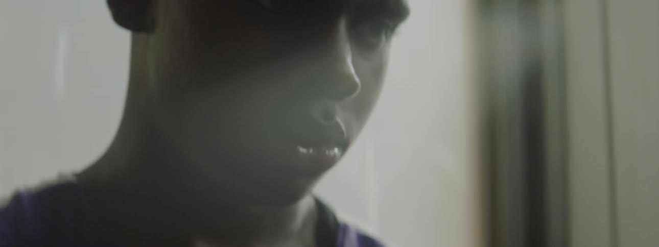 Young man standing indoors contemplating something