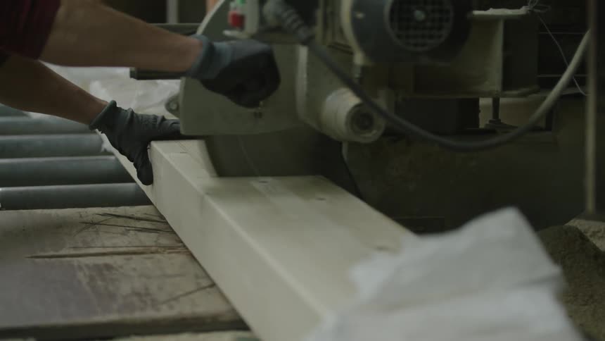 A person is cutting lumber with a table saw