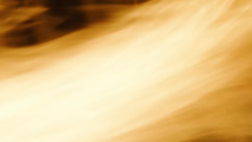 The flames of a fire are blazing brightly and rapidly moving as they illuminate the darkness