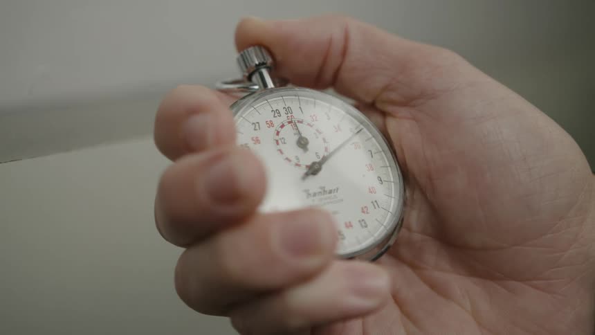Close up of a persons hand holding a stopwatch and pressing it down