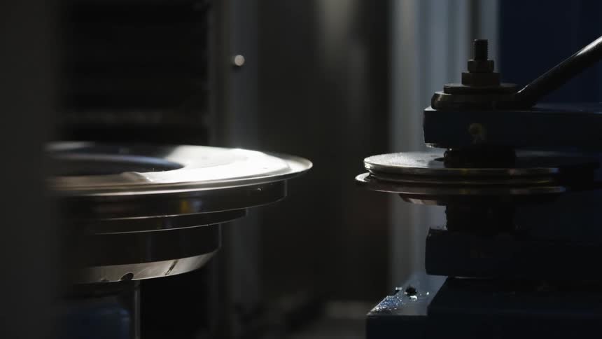 A man changes the metal disc in the machine