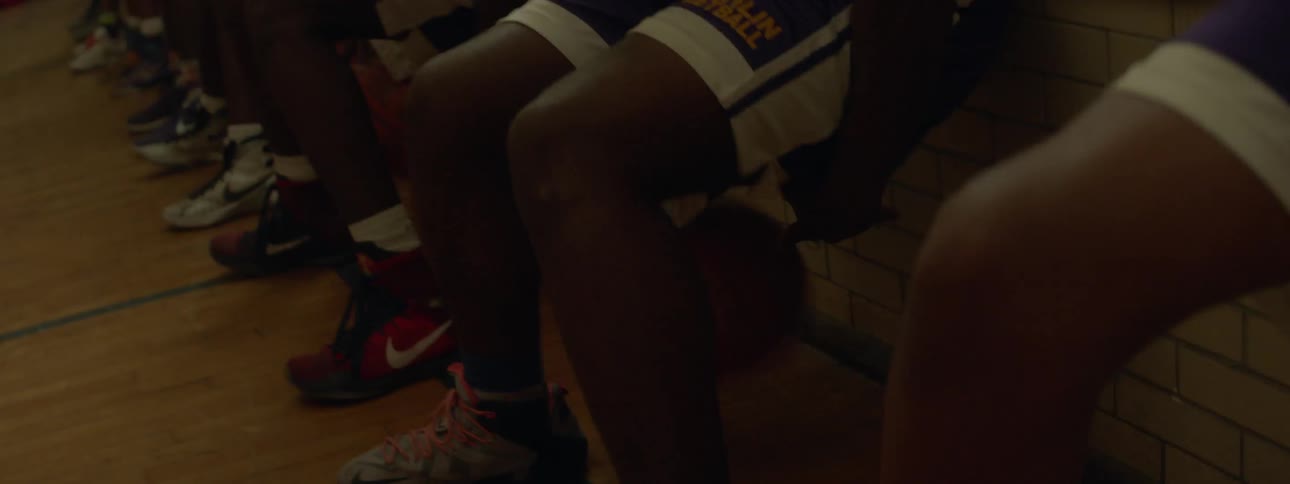 A group of basketball players are crouching dribbling between their legs