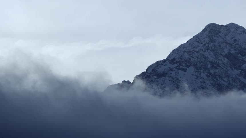 Spectacular Snowy Mountain Peak Shrouded in Clouds