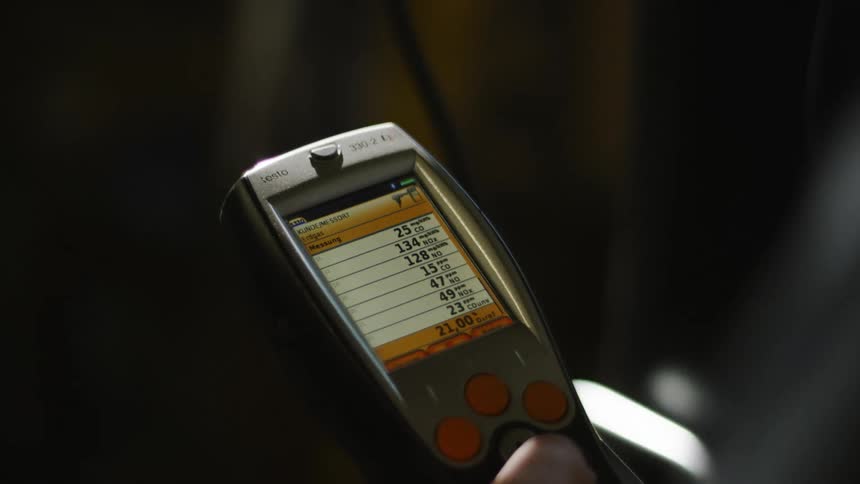 Close up of a worker typing on a handheld terminal inside a dimly lit room