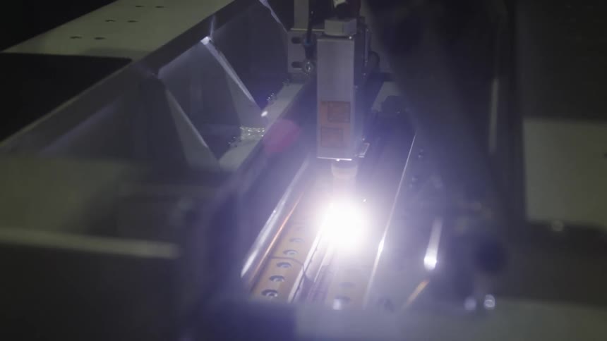 A bright light is emitted from a machine that has a probe on rails