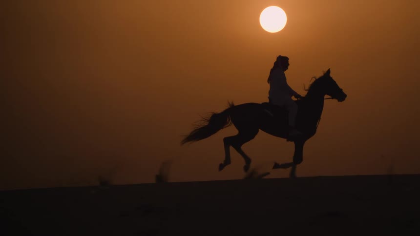 A woman rides a horse as the sun sets