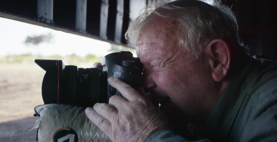 An older man looking through a camera