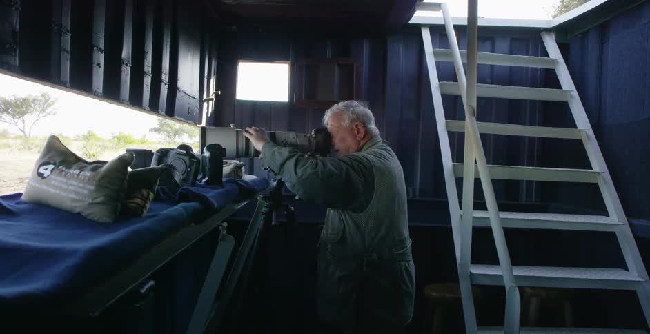 Elderly man adjusting his extremely large lens on a camera