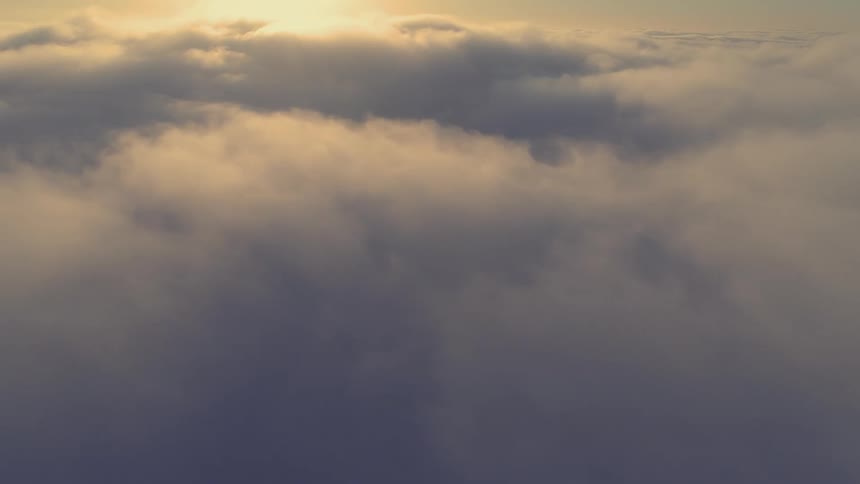 An aerial overview above dense cumulus clouds as the sun reflects off them