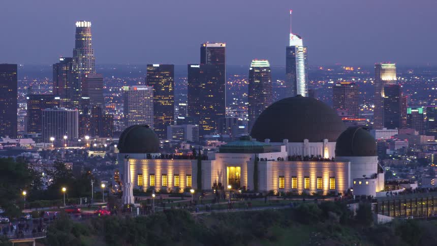 Time lapse of people visiting griffith observatory in front of city skyline
