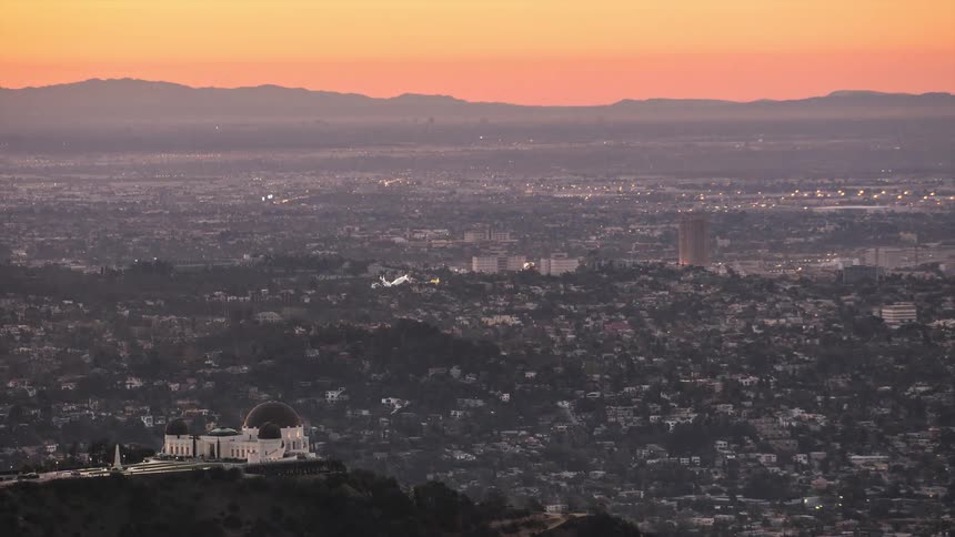 A time lapse of a city skyline from dawn until dusk as the lights birghten up the city at night