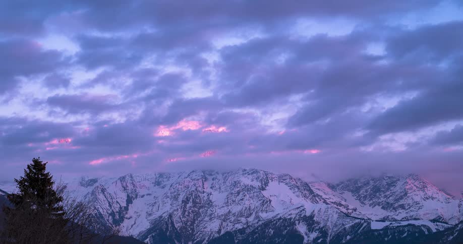 A time lapse shows clouds passing overhead above a mountain range